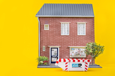 Rode bakstenen huisgevel steekt rechts uit (object), met wit kozijnraam en klein grijs pannendak, plantenbak met bloemen (actie/context); resten van het beeld tonen een effen heldergele achtergrond.
